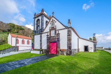 Historic Church of Santa Barbara das Manadas With a Vibrant Red Door and Bell Tower on Sao Jorge Island, Azores. Religious architecture, traditional design, cultural landmark, island heritage