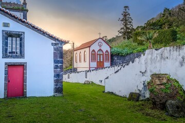 The historic Church of Santa Barbara das Manadas, featuring a striking red door and bell tower,...