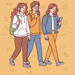 Three young people walk together through autumn park, talking and enjoying time outdoors in fall clothing