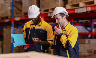 Warehouse manager, store inspector checking stock on storage shelf from inventory checklist. Two...