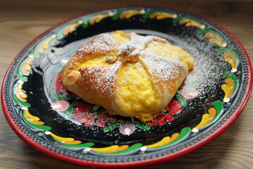 Cottage cheese bun, a Hungarian delicacy made from yeast dough and homemade goat cheese. Served on a hand-painted Hungarian folk art plate.
