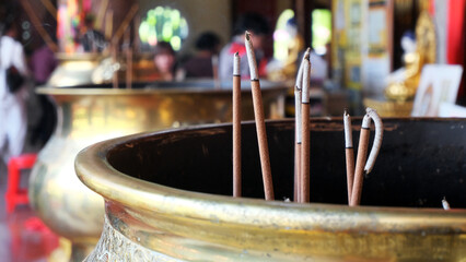 incense in a gold cauldron in front of a Buddhist temple. burning Incense sticks. incense sticks in...