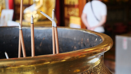 incense in a gold cauldron in front of a Buddhist temple. burning Incense sticks. incense sticks in a pot for praying
