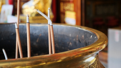 incense in a gold cauldron in front of a Buddhist temple. burning Incense sticks. incense sticks in...