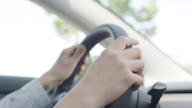 Close-Up of Female Hand Gripping Steering Wheel, Driving Scene