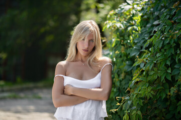 Outdoor portrait of beautiful young woman with green eyes at summertime.
