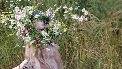 beautiful young woman in a wreath of flowers in the park © MARIA – Nature