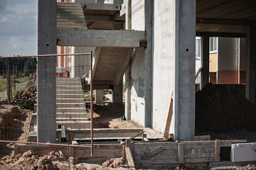 Construction site showing concrete staircase and building foundation in progress during daylight...