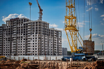Construction site showing a tower crane lifting materials for a new building in a city neighborhood