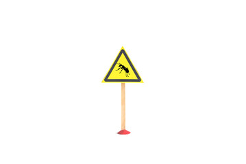 The warning sign is a silhouette of an ant insect in a yellow triangle on a light background. The sign 