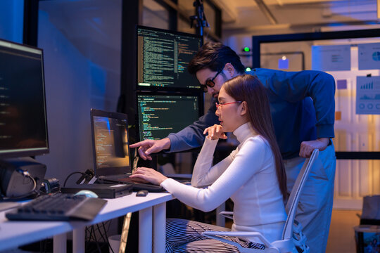 Asian software engineer or programmer team working late in development office,problem solving or algorithm of ai assistant helping for work.software developer,digital technology security concept