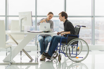 Colleagues business people woman man in chair for people with disability working on office. Startup business group team working together. Corporate professional team discussing project ideas