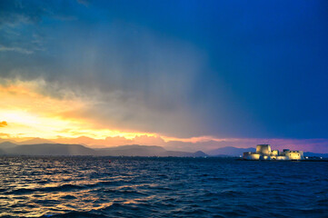 Dramatic sky sunset over the castle Bourtzi in Nafplio, Greece