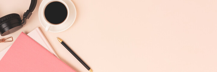 Banner with copybooks, cup of coffee and headphones on a beige background.
