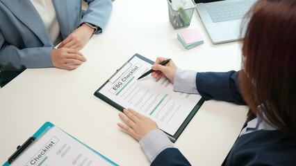 Asian female audit ESG risk check list paper form net zero waste supply chain vendor eco go green carbon credit control. Asia people woman give advice report prepare work review best practice process.