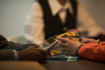 Black man holding digital voice recorder while sitting at table with Caucasian woman and middle...