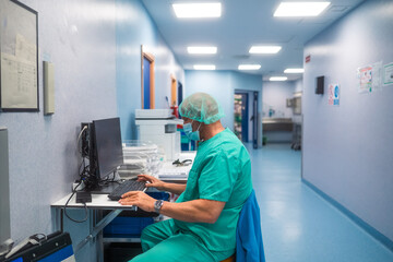 Surgeon working on computer in hospital corridor