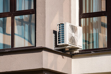Heating and air conditioning system external units on grass in a house backyard. Air conditioning...
