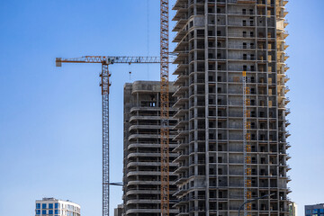 Construction crane on Housing. Construction site with buildings under construction. Tower cranes in...