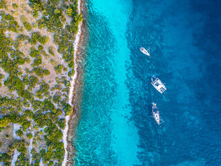 Sail boat and catamaran at a bay on blue turquoise water. Anchor in paradise