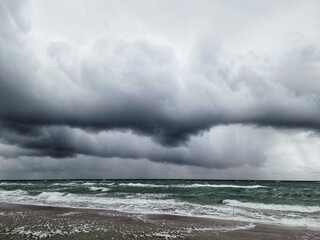 Eine Wetterfront über dem aufgewühlten Meer mit dunklen Wolken, Regen und Sturm