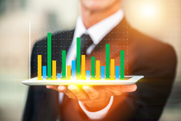 Businessperson Displays Growing Data Graph on Tablet. A close-up of a person in a suit holding a tablet computer.