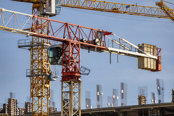 Large cranes in construction. An image of a tower crane against the background of a house under...