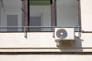 Outdoor air conditioning unit. A large modern air conditioner on the wall of an apartment building....