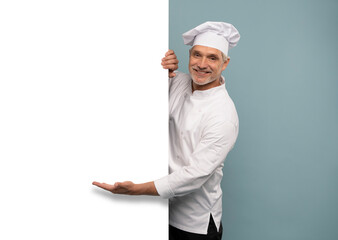 Mature male chef presenting something over blue background.
