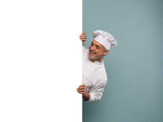 Mature male chef presenting something over blue background.
