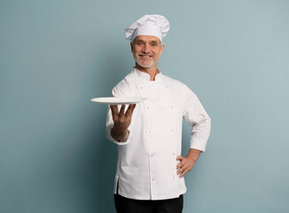 Portrait of chef, empty plate and smile, presenting menu special promo deal or restaurant product placement