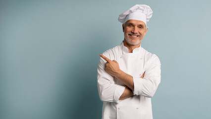 Mature male chef presenting something over blue background.