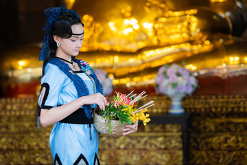 Pretty Asian women in ancient traditional Thai dress. Beautiful Thai dresses in Lanna style make merit according to tradition. Fashion portraits at the Chedi Luang temple in Chiang Mai, Thailand.