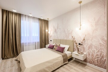 Cozy bedroom with beige bed, brown curtains, and floral wallpaper. Soft lighting creates a warm and inviting ambiance