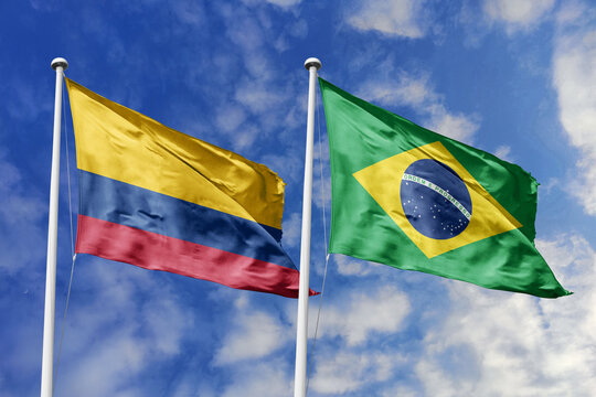 The Vibrant Flags of Colombia and Brazil Waving Together Under a Bright Blue Sky, Symbolizing Deep South American Brotherhood, Shared Amazonian Heritage, and Strong Diplomatic Ties. - Powered by Adobe