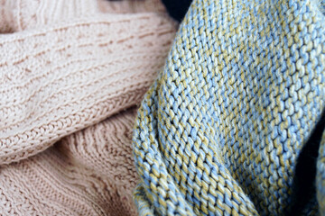 Soft knitted fabrics in cozy textures and pastel colors. A close-up capturing the warmth and...