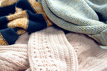 Eco-friendly knitted garments made from natural fibers in soft tones, close-up. Ideal for promoting sustainable fashion, organic materials, natural textures and conscious consumer lifestyle.
