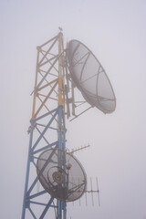Parabolic and directional antenna attached to a blue and yellow structure tower.