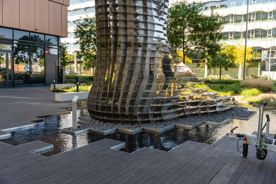 Prague, Czech Republic - September 21, 2024: Close-up of stainless steel sculpture leg by Czech artist David Cerny supporting a modern building in Karlin. Public art blending with architecture