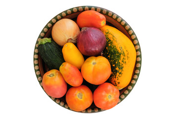 Variety of vegetables on a country plate isolated on white background. Organic tomato, zucchini, onion. Top view.