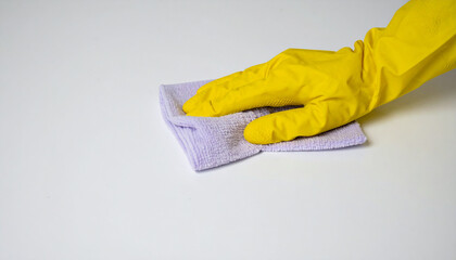 Person hand in yellow glove cleaning table with rag. Household cleaning, domestic chores.