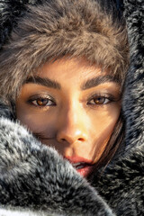 Stylish winter fashion shoot with brunette female model in snow-covered alpine landscape. Elegant...