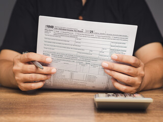 Close-up of hands reviewing U.S. income tax return document for financial planning.