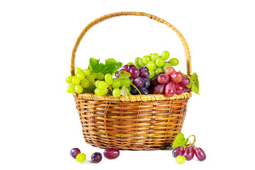 Bunches of green and red juicy grapes with leaves in a basket. Isolated on white.