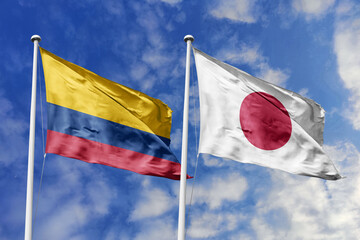 Colombia and Japan flags waving in unison against a clear blue sky, symbolizing strong...