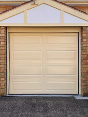 cream colour single wooden garage door against blonde brick wall