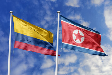 Colombia and North Korea flags flying side by side against a vivid blue sky, representing...