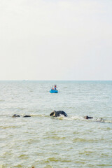 old man on a boat fishing in the sea from a distance