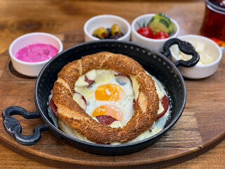 Traditional Turkish Breakfast with Simit bread baked with eggs and sunk sausage in a pan high angle view
