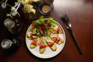 Smoked Duck Breast Salad with Avocado and Cherry Tomatoes on Wooden Table